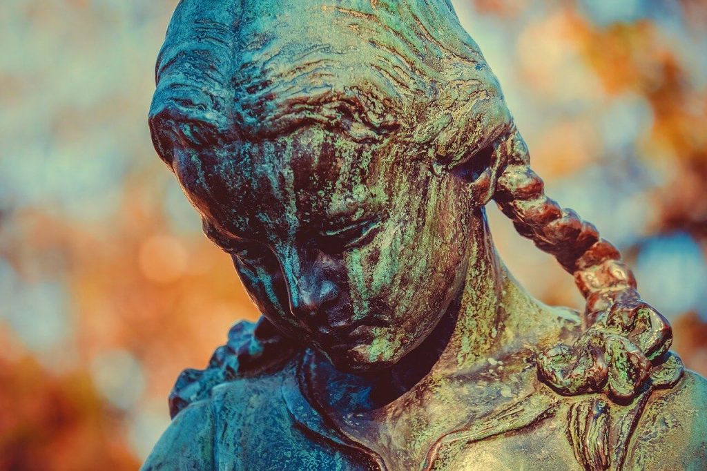 bronze verdigris statue of sad girl