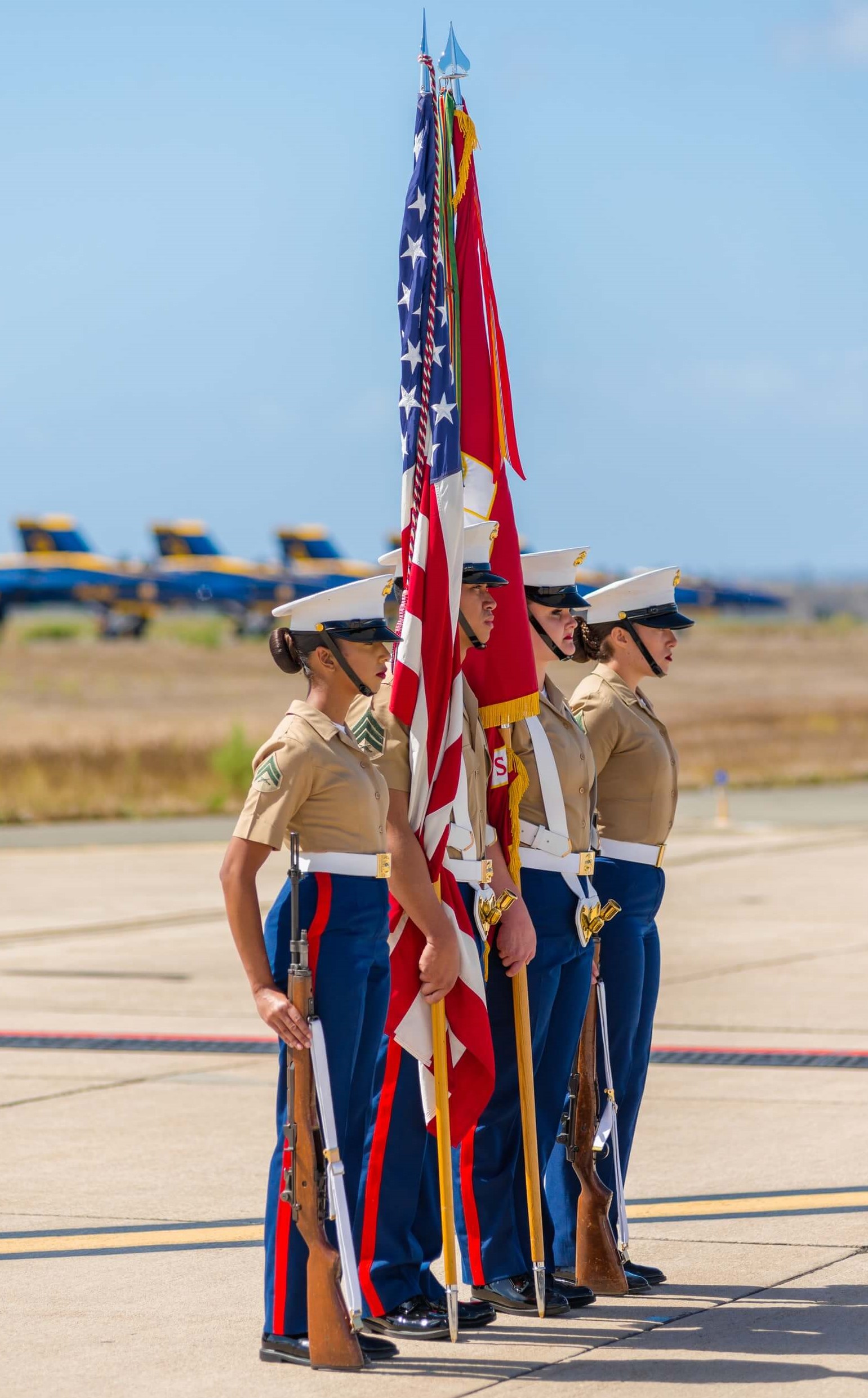 soldiers standing at attention with American and Marine Corps flags